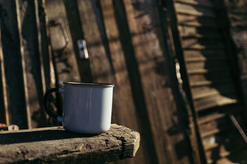 a cup of hot drink on a wooden table on a sunny day