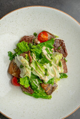 Warm salad with beef tender sauce and cherry tomatoes