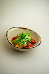 hot salad with beef, mushrooms and cherry tomatoes on the background