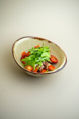 hot salad with beef, mushrooms and cherry tomatoes on the background
