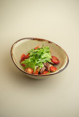 hot salad with beef, mushrooms and cherry tomatoes on the background