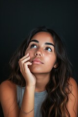 Thoughtful Young Woman Posing Against Dark Background