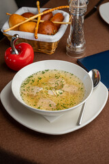 chicken soup with a basket of bread in a restaurant