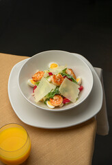 Caesar salad with shrimp and Parmesan in a cozy restaurant