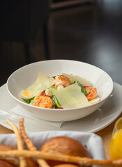 Caesar salad with shrimp and Parmesan in a cozy restaurant