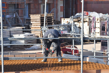 maçon posant des briques sur un chantier de construction d'un bâtiment d'habitation
