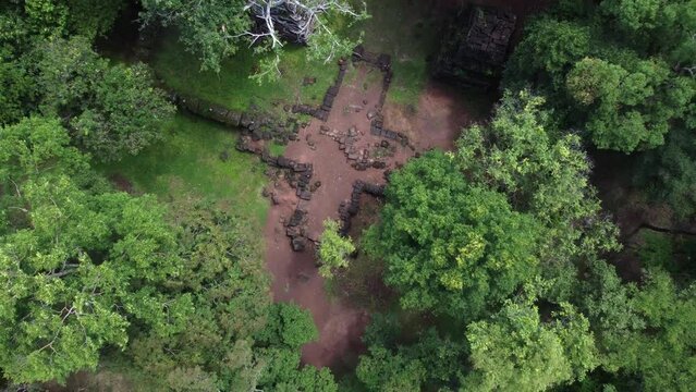 Jungle aerial rises over ancient stonework at overgrown Koh Ker Temple