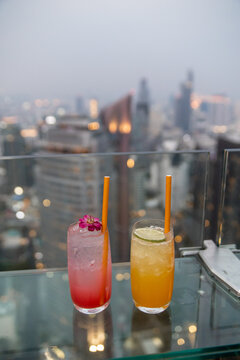 two colorful cocktails at rooftop bar in bangkok, thailand