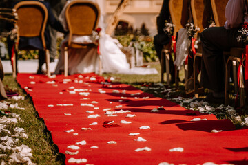 Valmiera, Latvia - August 19, 2023 - A red carpet with white rose petals at a wedding ceremony...