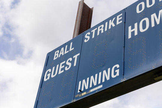 Baseball scoreboard under cloudy sky