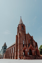 Fototapeta premium Red sandstone church against bright blue sky
