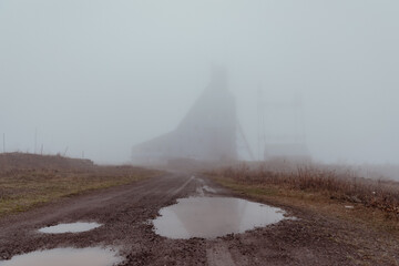 Mine shaft in the distance during a foggy spring day