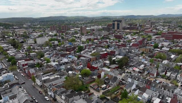 Wide aerial shot of an American city. Drone view flying towards downtown skyscrapers above row houses and neighborhoods.