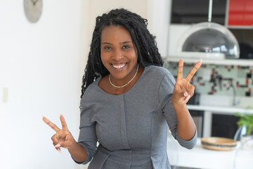Excited black businesswoman with dreadlocks and fashionable dress