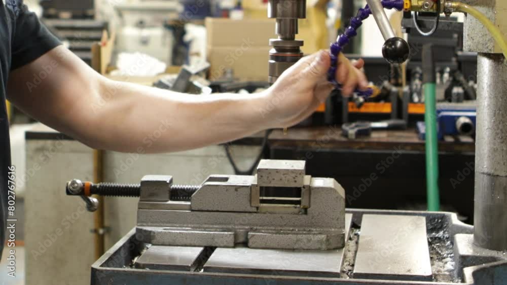 Aufkleber worker operating a pillar drill in an industrial setting, creating precision components