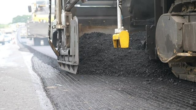 Special machinery making road in countryside area. Compactor constructing highway. Heavy machinery repairing road. Slowly driving roller laying new asphalt layer. Roadwork process. Roadway repair