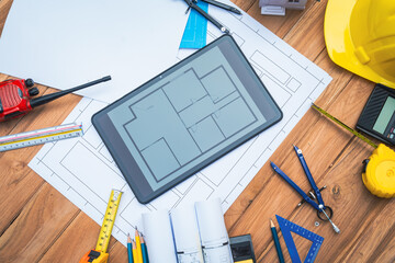 Top view desk of Engineer tools meticulously designs structures at desk, referring to blueprints...
