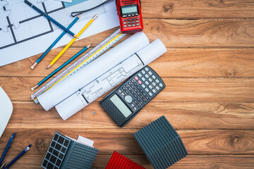 Top view desk of Engineer tools meticulously designs structures at desk, referring to blueprints...