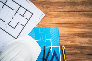 Top view desk of Engineer tools meticulously designs structures at desk, referring to blueprints...