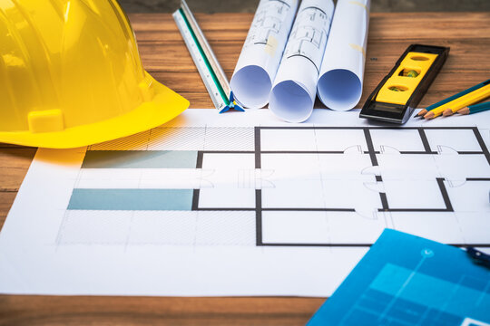 Top view desk of Engineer tools meticulously designs structures at desk, referring to blueprints for precision. Focuses on innovation, problem-solving, and attention to detail in engineering projects