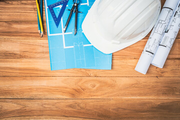 Top view desk of Engineer tools meticulously designs structures at desk, referring to blueprints...