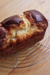 Homemade baked Brioche Bread on a cooling rack on wooden table