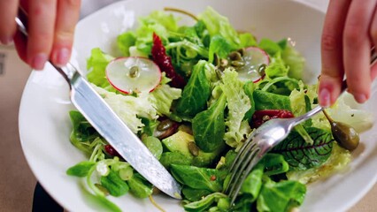 Woman eating a fresh salad at a restaurant