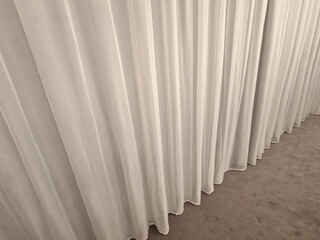 the curtain hangs from the ceiling to the floor. smooth satin synthetic curtain dividing the space...