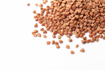 Brown buckwheat grains pile on white background. Dry buckwheat grains. Top view