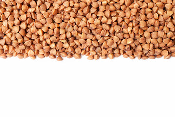Uncooked, dry, brown buckwheat grains border on white background. Copy space for text. Top view
