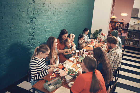 Diverse group of friends and family taking an arts and crafts class during a bonding activity at the weekend