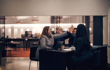 Businesswomen high-fiving during a meeting together in a hotel lobby