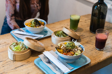 Woman having good time, drinking fresh juices and having healthy breakfast in the cafe