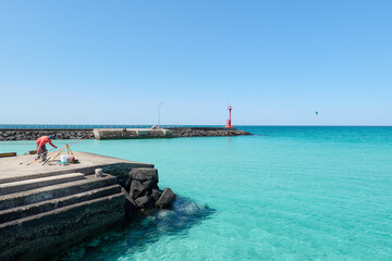 Clear and transparent sea and sky scenery. A man fishing. Jeju island.