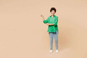 Full body young woman of African American ethnicity wear green shirt casual clothes point index...