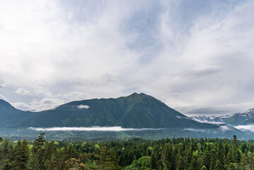 Obraz premium Beautiful panoramic view of the mountains. Arkhyz, Karachay-Cherkessia. Aerial beautiful summer landscape of the Caucasus mountains in the fog.