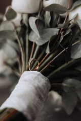 A bouquet of white flowers with a ring on a stem. The ring is a symbol of love and commitment