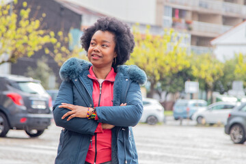 afro woman with arms crossed on the street