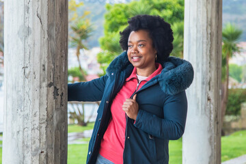 afro woman posing on the street with  jacket