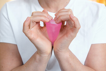 Pink Color Silicone Menstrual Cup In the Femmale Hands.  Comfortable Reusable Period Cup, Tampon...