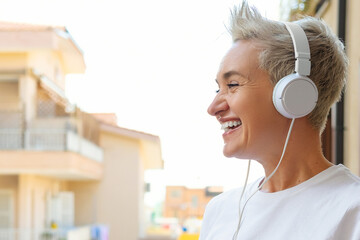 Middle Aged Woman With Short Haircut Listening To Music With Her Smartphone. Audiobook or Podcast...