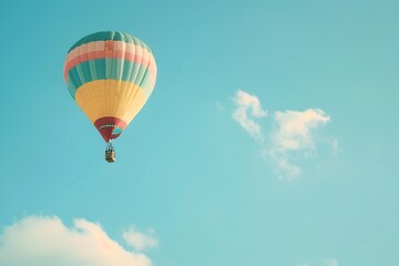Fototapeta premium Colorful Hot Air Balloon Soaring Through Serene Clear Blue Sky on a Whimsical Aerial Adventure