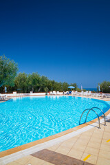 Swimming pool on sunny day by sea