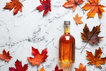 Bottle of golden Canadian maple syrup with red maple leaves scattered