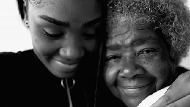 African American Granddaughter Hugging Elderly 80s Grandmother in black and white, monochrome. Family unity and affection - taking care of senior grandparent