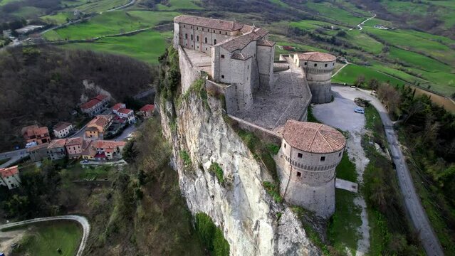Unique beautiful places of Italy. Emilia Romagna region. Aerial drone view of impressive San Leo medieval castle located in the top of sandstone rock and village