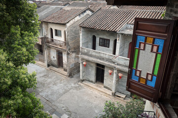 Old Chinese village houses and a colourful glass window in the foreground in Southern China