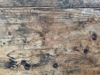Close-up shot of an old wood surface with intricate details, scratches, knots and colors