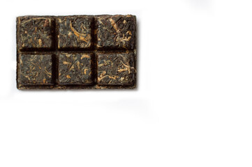 Dry pressed tea leaves on a white background with space for text. Pressed red tea in the form of tiles