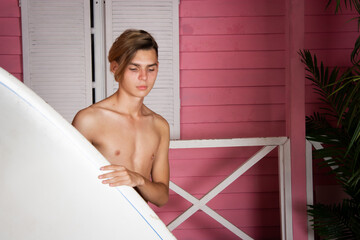 A young attractive guy is resting by the sea. Beach and surfing.